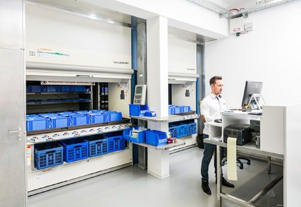 Ein Lager mit automatisierten Regalsystemen und einer Person an einem Computer.